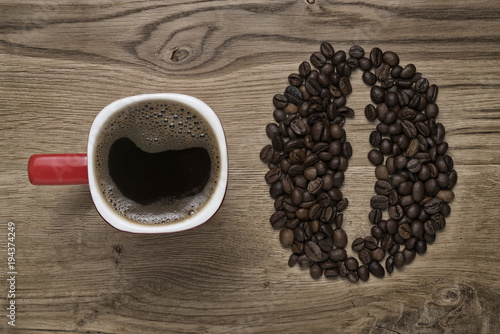 red mug on the background of scattered coffee beans