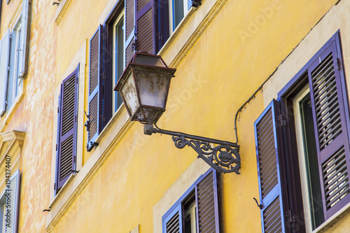 ROME, ITALY, on March 7, 2017. The sun lights the beautiful ancient lamp decorating a building facade in a historical part of the city photo