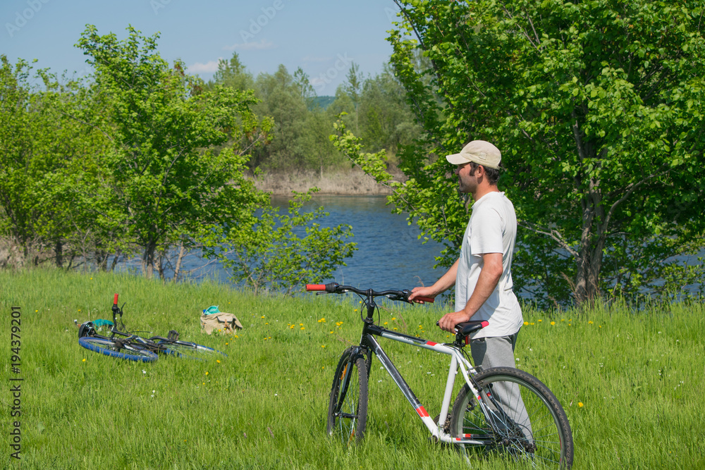 Obraz premium A young man with a Bicycle on nature background