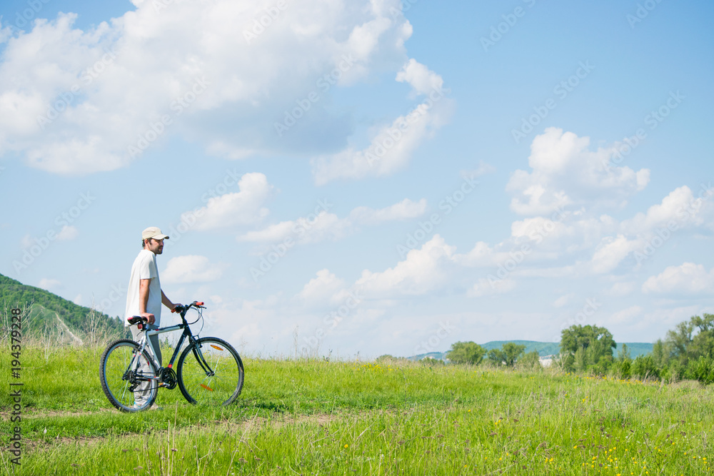 Fototapeta premium A young man with a Bicycle on nature background