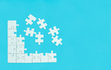 White jigsaw of puzzle on blue background.