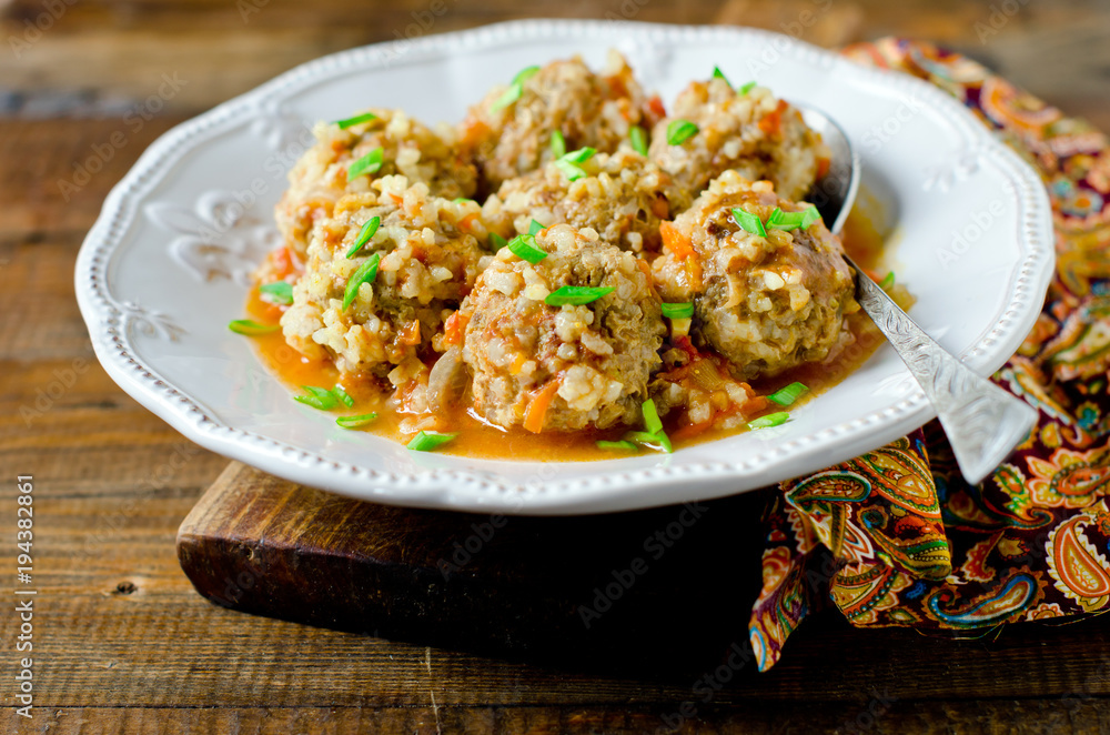 Meatballs stewed with tomato sauce in a plate on a wooden table Meatballs stewed with tomato sauce in a plate on a wooden table