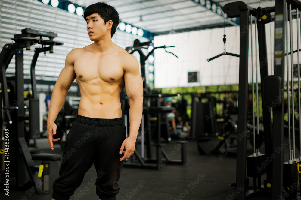 Naklejka premium strong fitness man posing muscular body and doing exercises for bodybuilder in the gym, fitness concept, sport concept