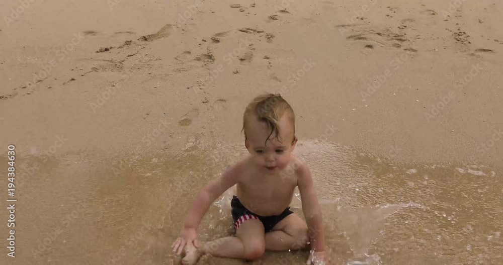 Back view of little child and father running together on wet sandy beach. Back view of little child and father running together on wet sandy beach.