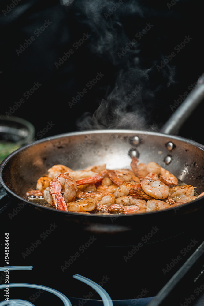 Shrimp on frying pan. Thermal processing of food. Electric cooker in a restaurant Shrimp on frying pan. Thermal processing of food. Electric cooker in a restaurant