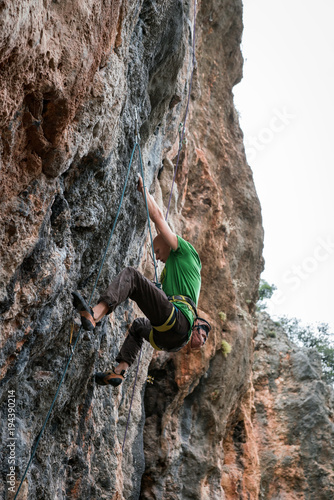 bald man climbs rock, side view, Turkey