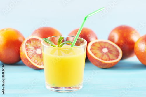 orange juice in glass with mint and a straw