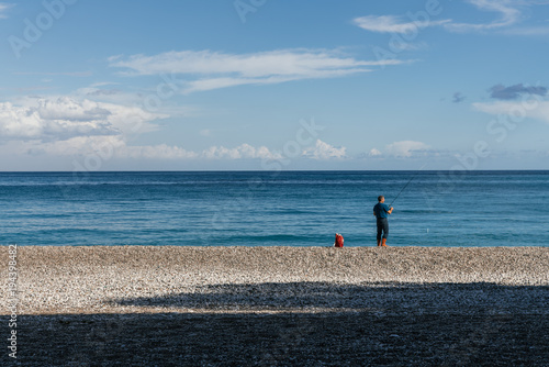 Fisher in red boots is on the cost of the sea
