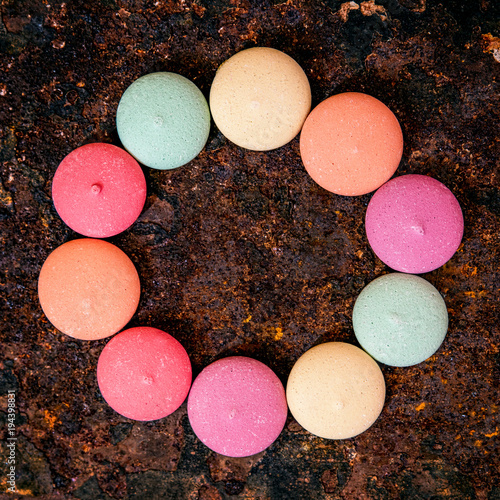 Draufsicht, Hintergrund Rost mit Macarons bunt oder Keksen in einerm Kreis photo