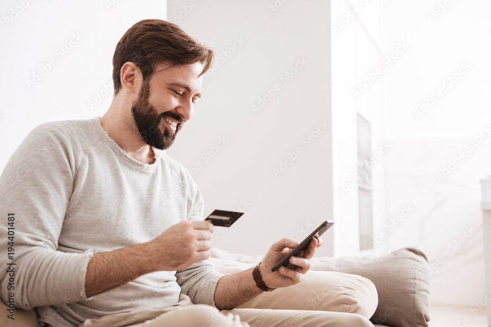 Portrait of a cheerful man shopping online Portrait of a cheerful man shopping online