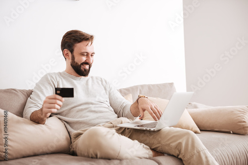 Portrait of a satisfied man shopping online with credit card © Drobot Dean