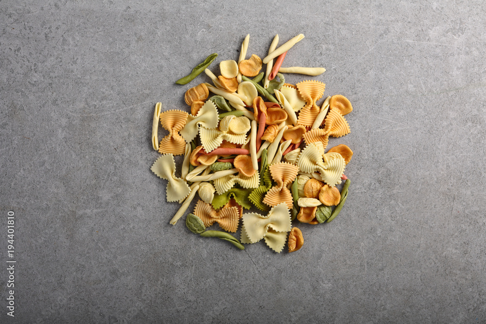 Different types of pasta on gray background