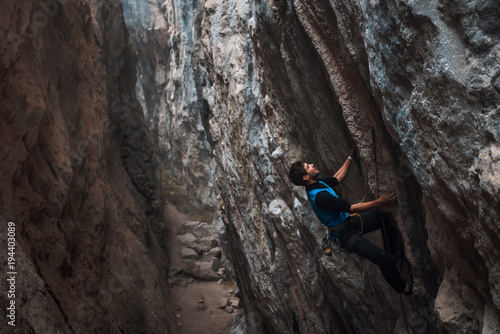 Men climbs a rock with a rope, lead, in cold weather. Hard pitches. Chitdibi, Turkey