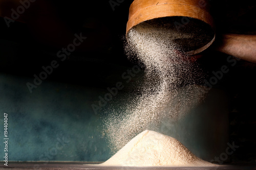Canvas Print Sifting flour from old sieve.