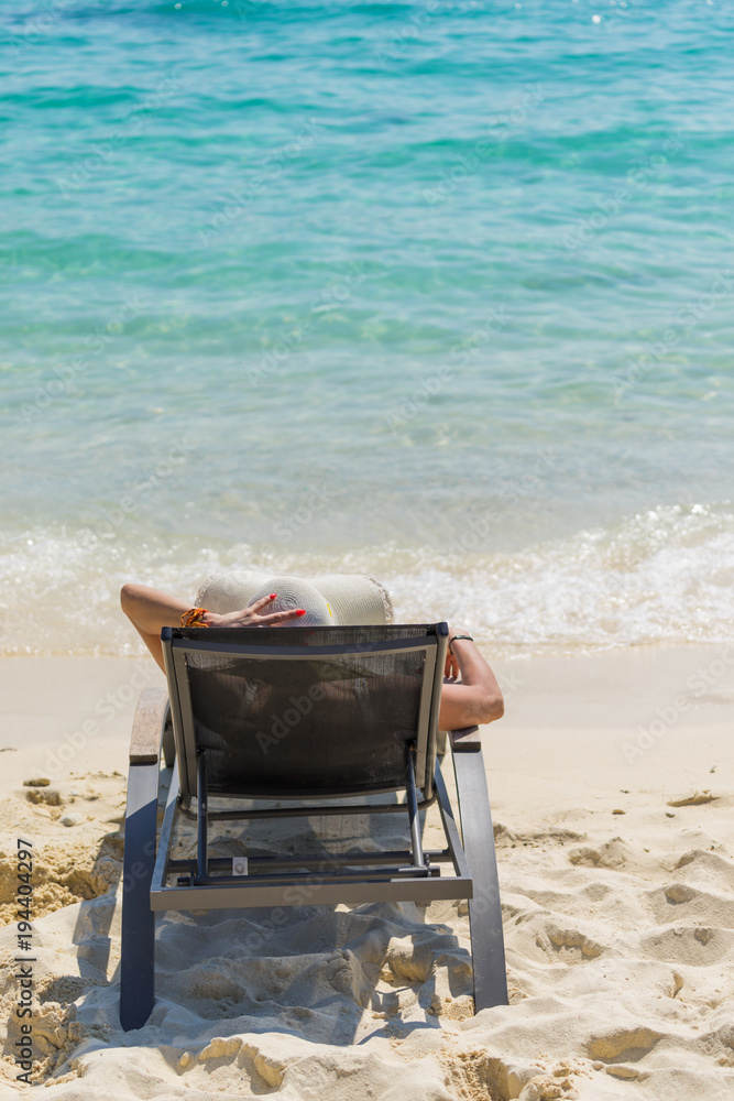 Cute woman relaxing on a sunbed and look to the sea shore. Cute woman relaxing on a sunbed and look to the sea shore.