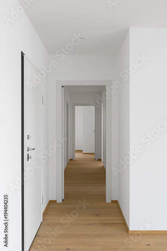 Empty white corridor with open doors