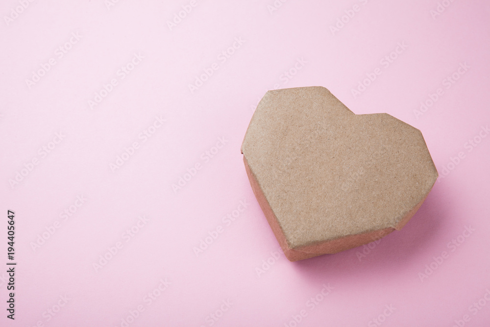 Paper heart made from recycled paper on a pink background, empty space for text. Paper heart made from recycled paper on a pink background, empty space for text.