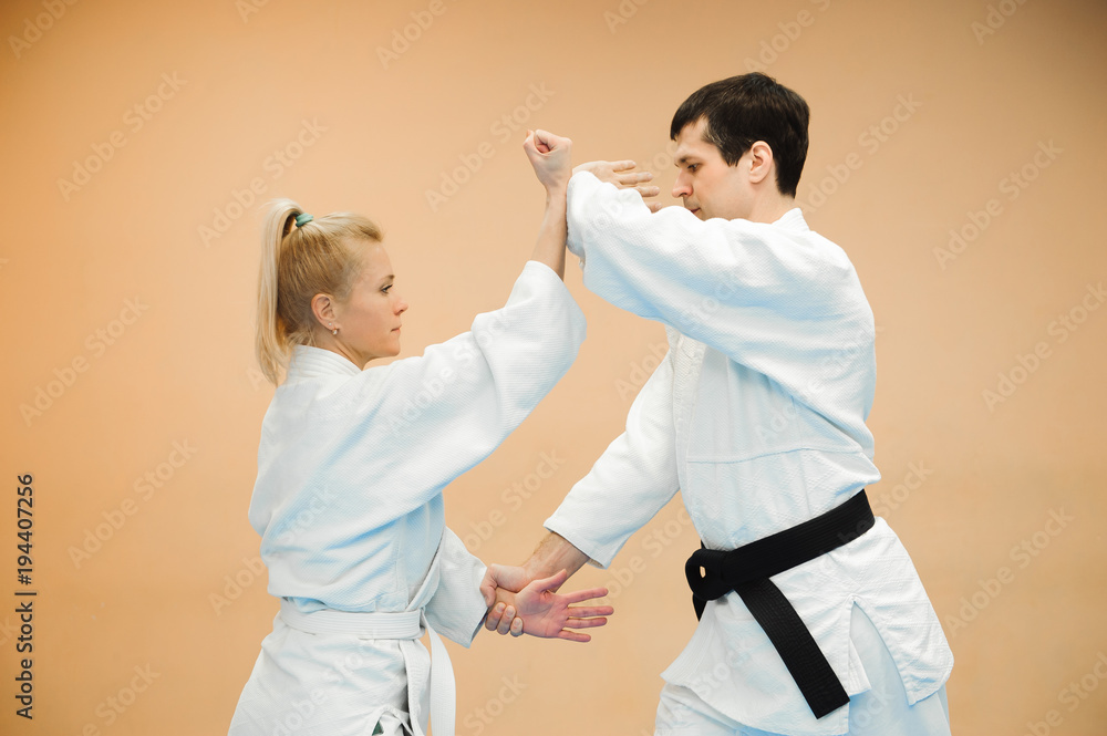 Obraz premium Man and woman fighting at Aikido training in martial arts school