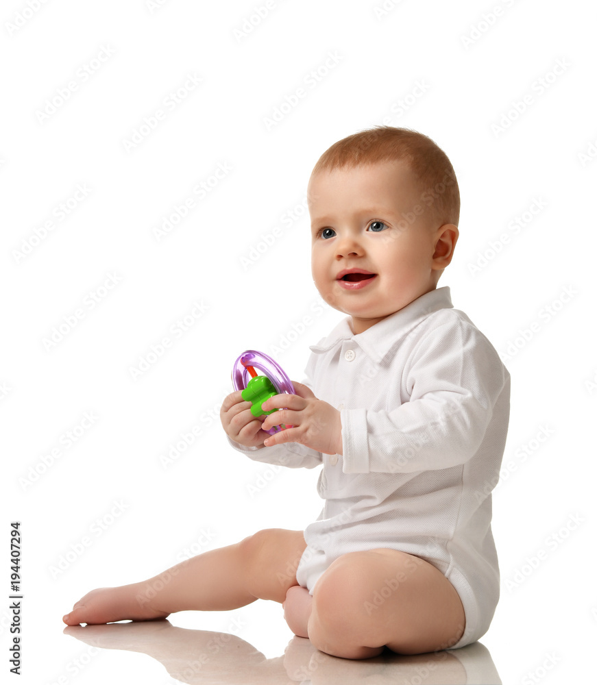 Infant child boy toddler sitting with plastic toy isolated Infant child boy toddler sitting with plastic toy isolated
