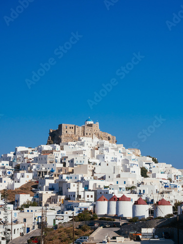Chora of Astypapaia island ,Greece at daytime with the white houses that encircle the castle and the white windmills with the red roofs.