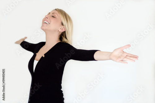 Tableau sur toile Adorabile donna piena di felicità che loda la libertà con le braccia alzate verso il cielo e gli occhi chiusi