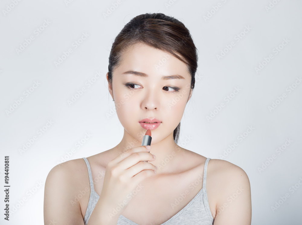 口紅を塗っている若い女性 口紅を塗っている若い女性