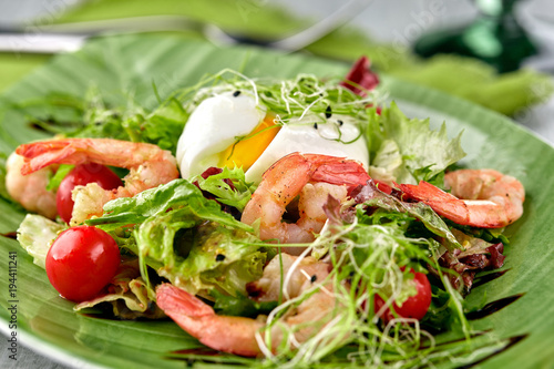 Salad from shrimp with lettuce, arugula, eggs, tomatoes, olive oil and balsamic vinegar.