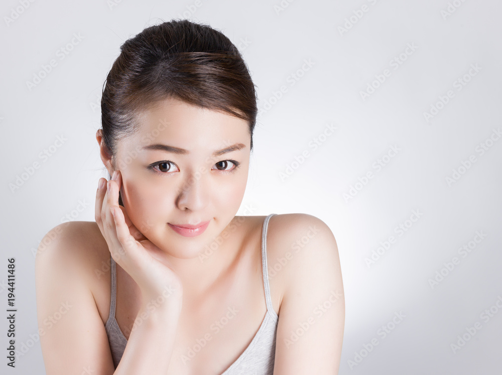 頰に手を当てて肌のチェックをする女性 頰に手を当てて肌のチェックをする女性