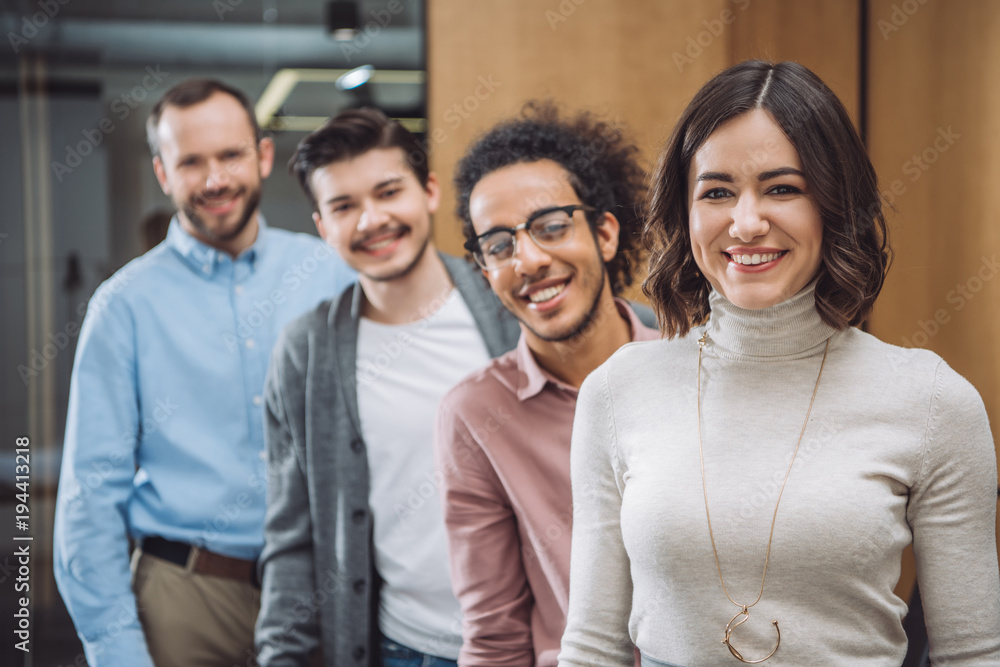 Obraz premium group of successful businesspeople standing in row and looking at camera at office