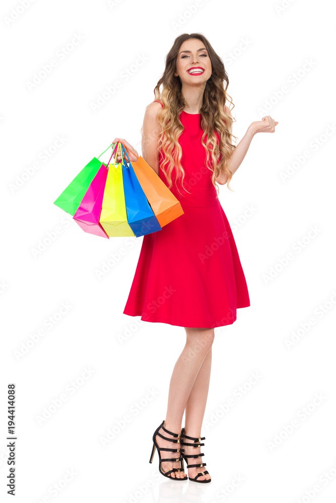Happy Woman In Red Dress With Colorful Shopping Bags