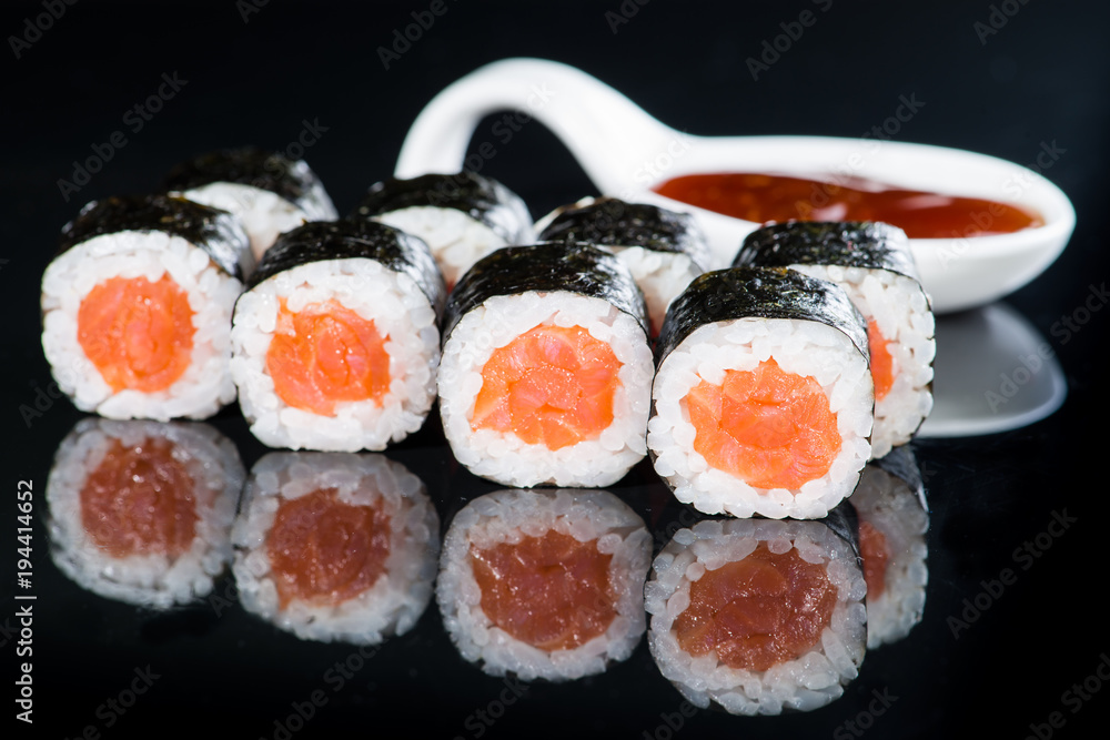 Fresh delicious Japanese sushi with salmon on dark background Fresh delicious Japanese sushi with salmon on dark background