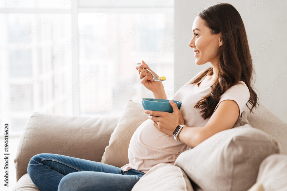 Smiling pregnant young woman having healthy breakfast Smiling pregnant young woman having healthy breakfast