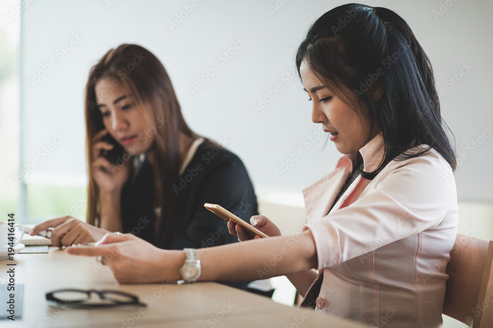 Young woman worker talking with smartphone in office Young woman worker talking with smartphone in office