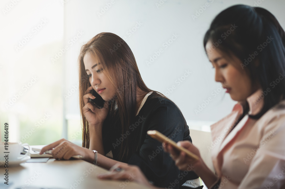 Young woman worker talking with smartphone in office Young woman worker talking with smartphone in office