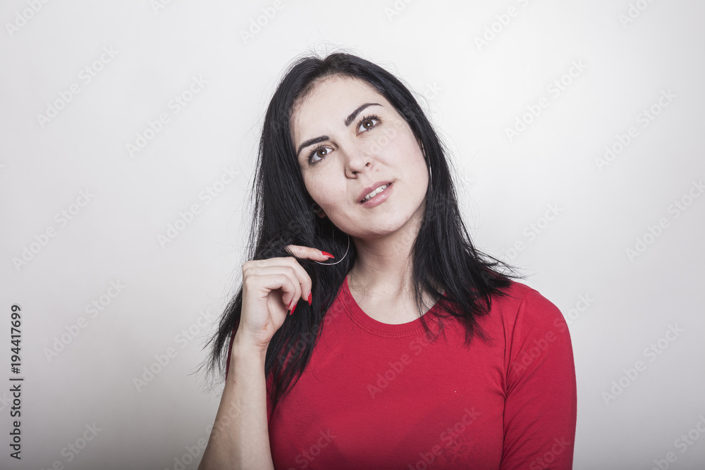 Hochnäsige Frau in rotem Shirt mit schwarzen langen Haaren Hochnäsige Frau in rotem Shirt mit schwarzen langen Haaren