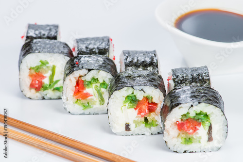 Tasty fresh Sake Avocado Maki sushi with rice, avocado, tobiko and salmon on light background