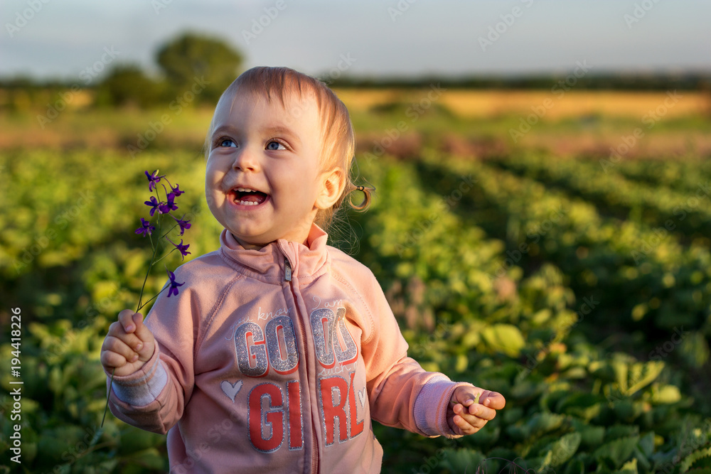 Portrait of a smiling little girl standing in the garden Portrait of a smiling little girl standing in the garden