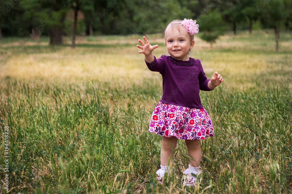 Portrait of little girl standing on green grass Portrait of little girl standing on green grass