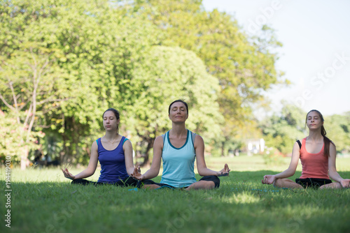 Mother and daughter with yoga exercise outdoors at the park. Health and Fitness concept