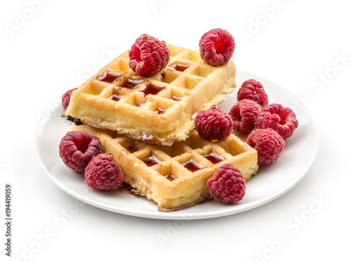Traditional waffle (Belgian) with fresh raspberries on a saucer and honey isolated on white background two sweet delicate and airy delicious breakfast.