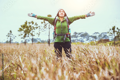 Asian women travel nature. Travel relax.Backpack walk on the meadow in the forest. Thailand