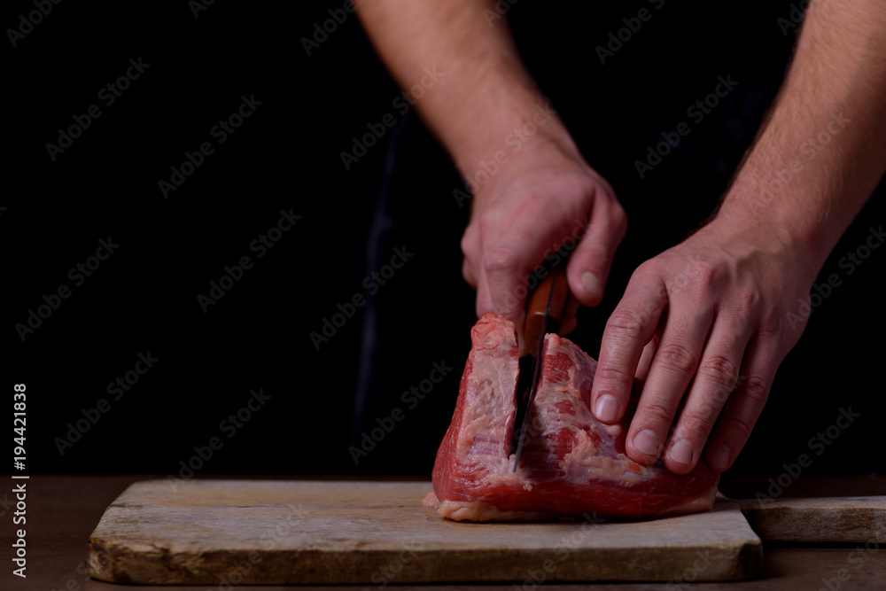 Butcher cutting beef meat on kitchen
