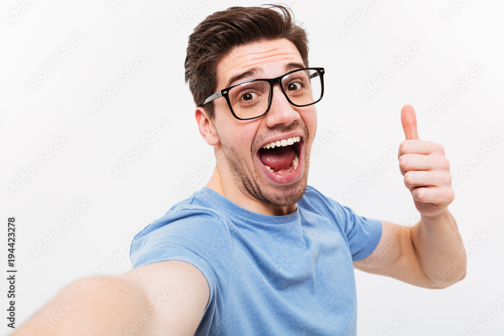 Joyful man in t-shirt and eyeglasses making selfie Joyful man in t-shirt and eyeglasses making selfie