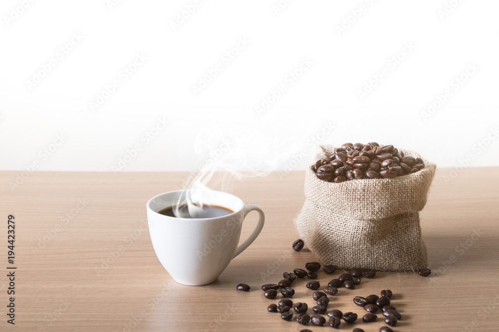Coffee cup with coffee beans placed on a wooden table. Coffee cup with coffee beans placed on a wooden table.