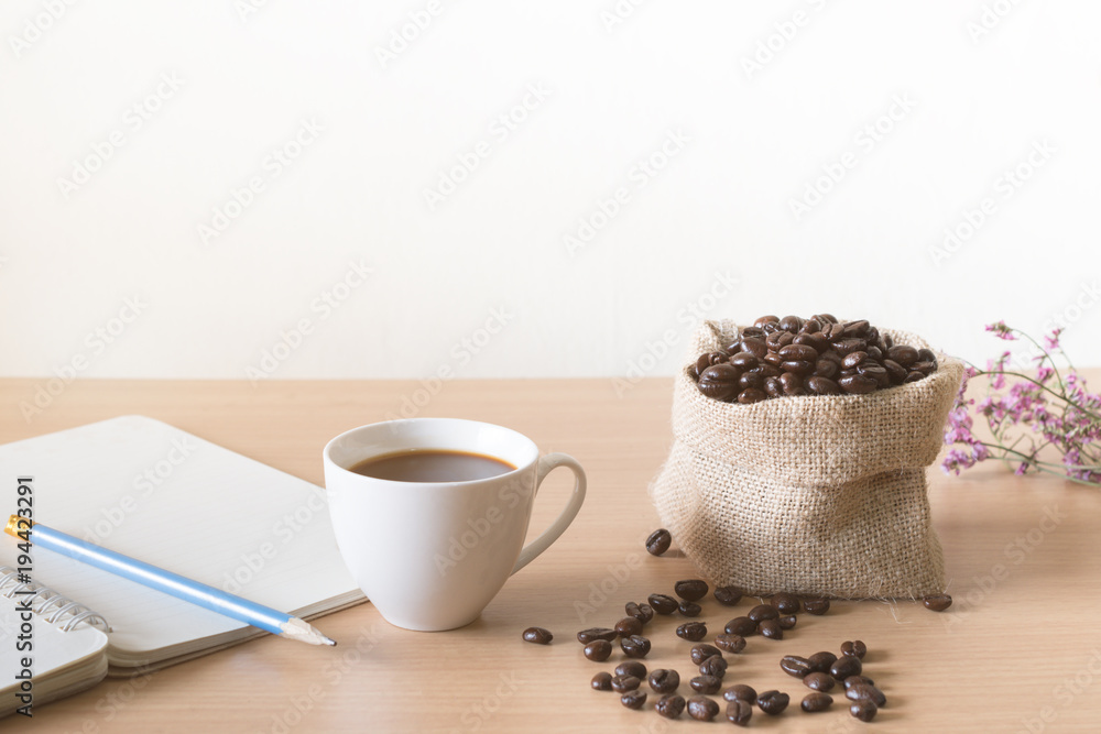 Coffee cup with coffee beans placed on a wooden table. Coffee cup with coffee beans placed on a wooden table.