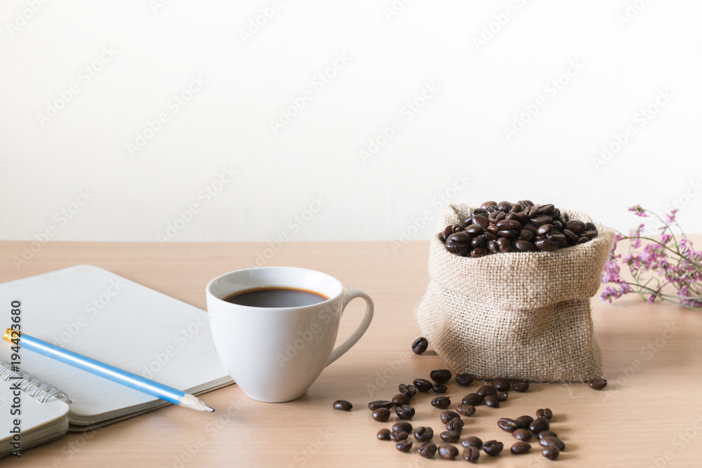 Coffee cup with coffee beans placed on a wooden table. Coffee cup with coffee beans placed on a wooden table.