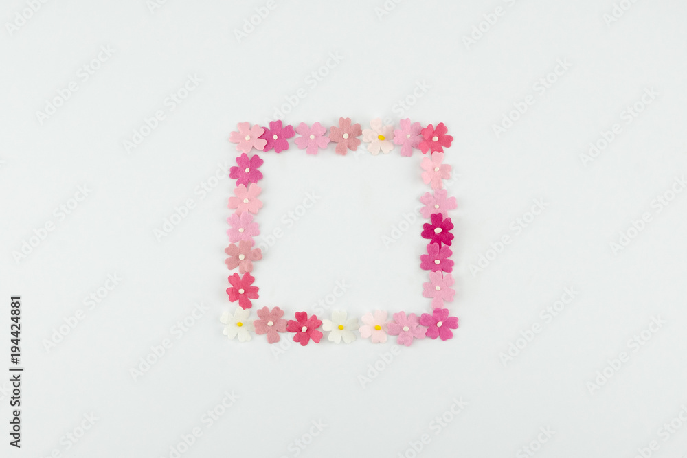Pink tone paper flowers square wreath on white background with copy space
