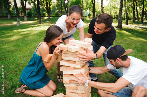 Friends playing board game outdoors.