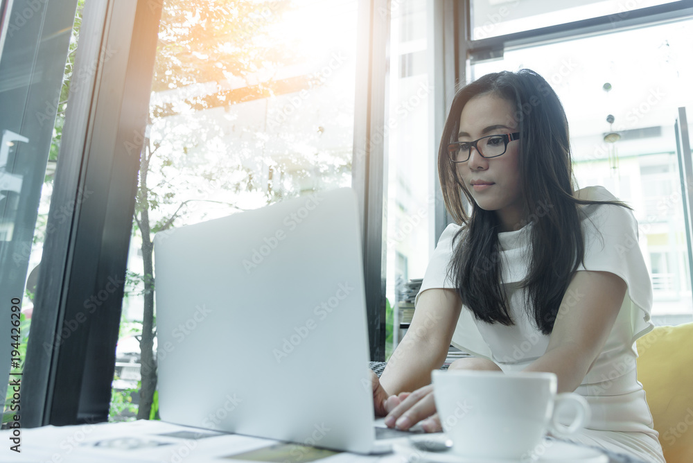 Beautiful asian attractive woman has working and typing on laptop computer for business marketing at coffee cafe in the morning with happy and relaxing time. Beautiful asian attractive woman has working and typing on laptop computer for business marketing at coffee cafe in the morning with happy and relaxing time.