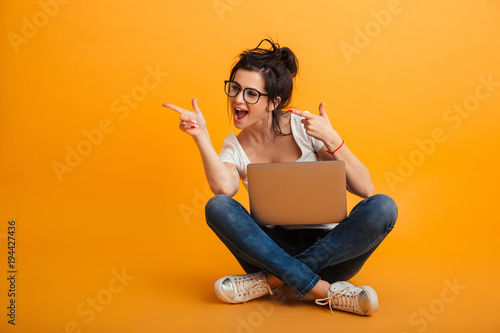 Εκτύπωση καμβά Photo of woman in casual clothing and eyeglasses sitting on floor in lotus pose